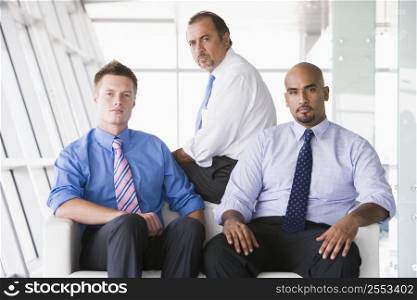 Three businessmen sitting indoors (high key/selective focus)