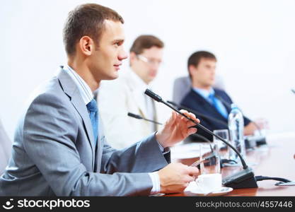 Three businesspeople at meeting. Image of three businesspeople at table at conference