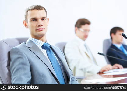 Three businesspeople at meeting. Image of three businesspeople at table at conference