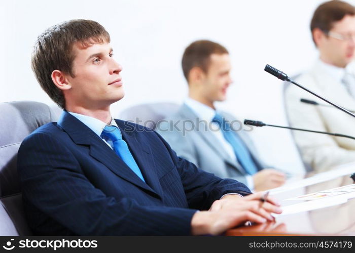 Three businesspeople at meeting. Image of three businesspeople at table at conference