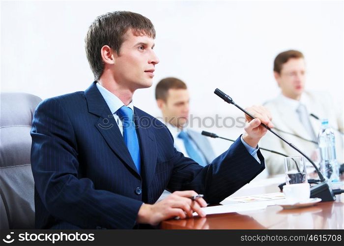 Three businesspeople at meeting. Image of three businesspeople at table at conference