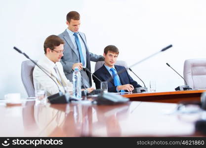 Three businesspeople at meeting. Image of three businesspeople at table at conference