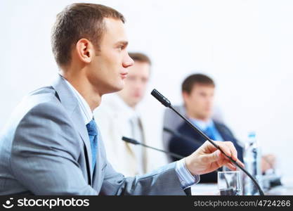 Three businesspeople at meeting. Image of three businesspeople at table at conference