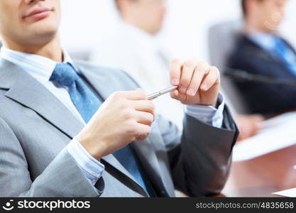 Three businesspeople at meeting. Image of three businesspeople at table at conference