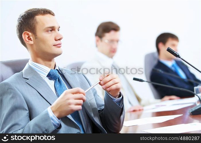 Three businesspeople at meeting. Image of three businesspeople at table at conference