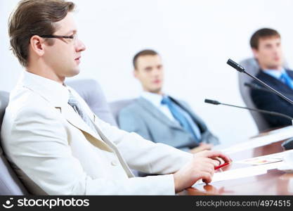 Three businesspeople at meeting. Image of three businesspeople at table at conference