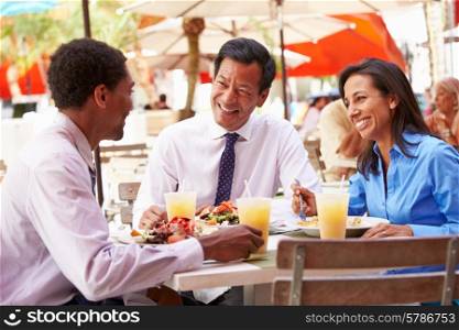 Three Businesspeople Having Meeting In Outdoor Restaurant