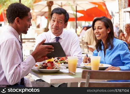 Three Businesspeople Having Meeting In Outdoor Restaurant