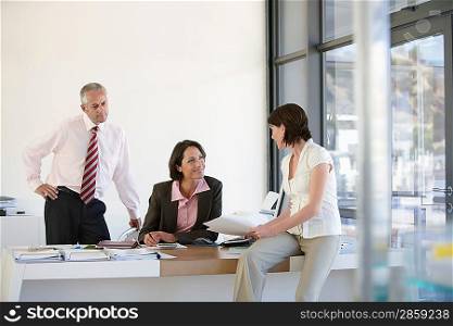 Three businesspeople in office having business meeting.