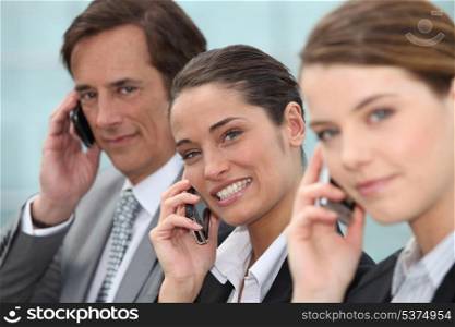 Three businesspeople on phone