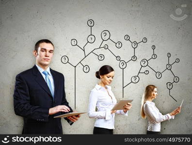 Three businesspeople with tablet pc in hands. Three young people with tablet pc in hands