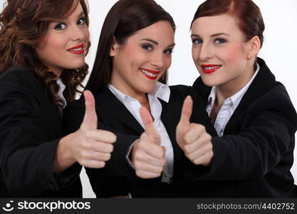 Three businesswomen giving the thumbs-up