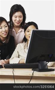 Three businesswomen looking at a computer
