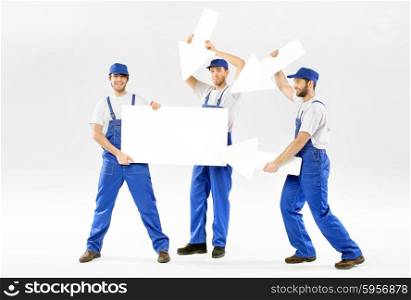 Three cheerful workers with empty board