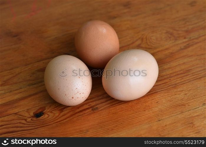 three chicken eggs on wooden background