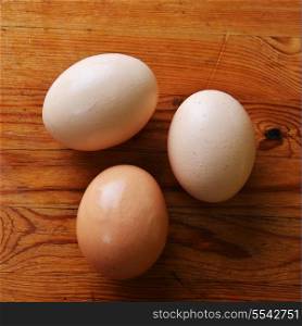 three chicken eggs on wooden background