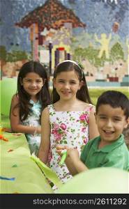 Three children at a birthday party in a park