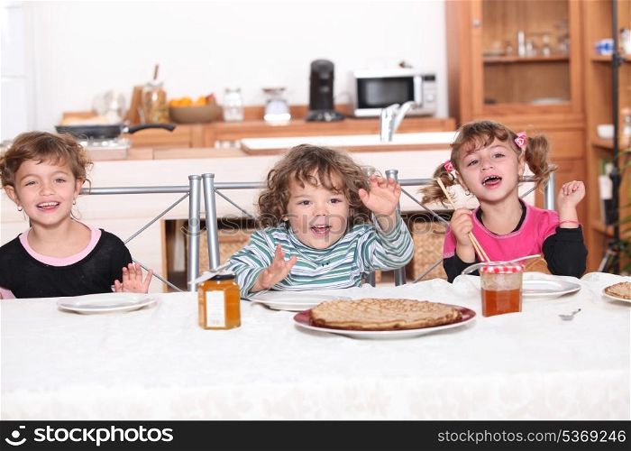 Three children gathered around breakfast table