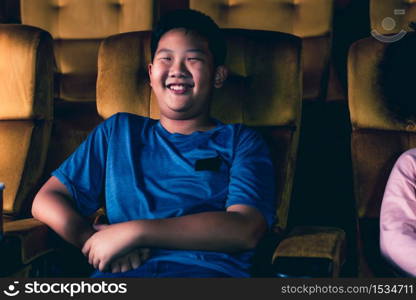 Three children having fun and enjoy watching movie in cinema