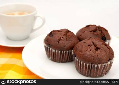 Three Chocolate Muffins With BlueBerries and Espresso Coffee on Orange Tablecloth