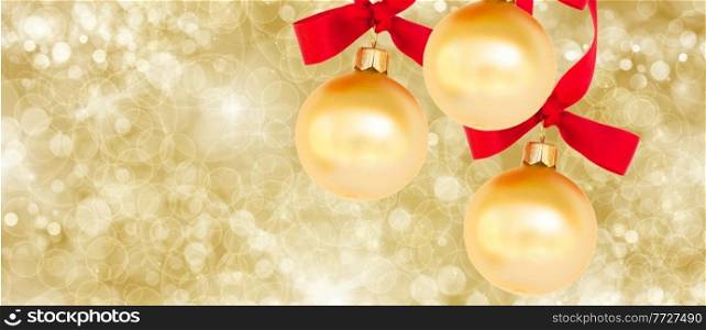 three christmas balls on golden background with sparkles. three christmas balls on golden background