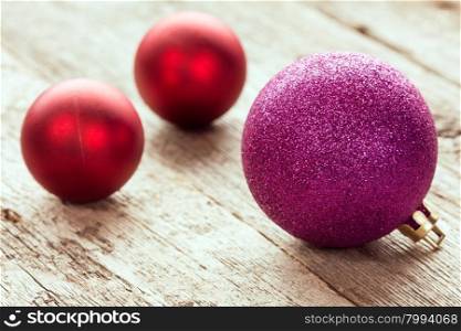 Three Christmas balls on old wood background
