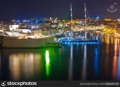 Three cities as seen from Valletta at night, Malta. Aerial skyline view of ancient defences of Birgu and Fort St. Angelo, as seen from Valletta at night, Malta.