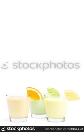 three cold citrus fruit milkshakes. three cold citrus fruit milkshakes on white background