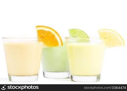 three cold citrus fruit milkshakes. three cold citrus fruit milkshakes on white background