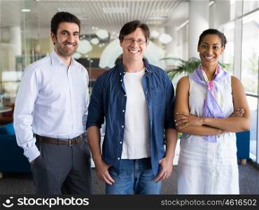 Three collegues standing next to each other in an office