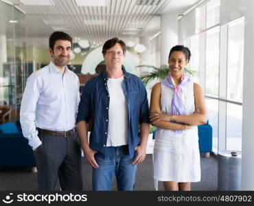 Three collegues standing next to each other in an office