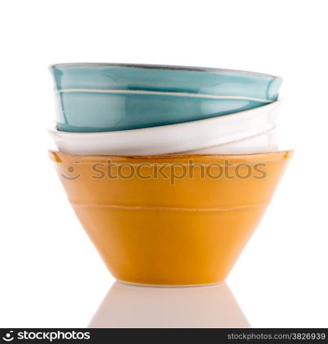 Three colored bowls on white reflective background