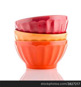 Three colored bowls on white reflective background