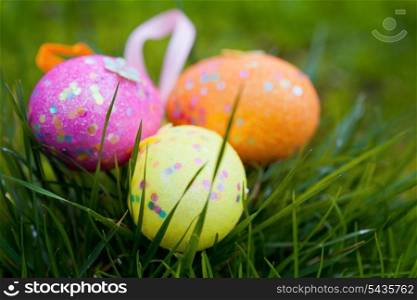 three colorfull easter eggs on green grass