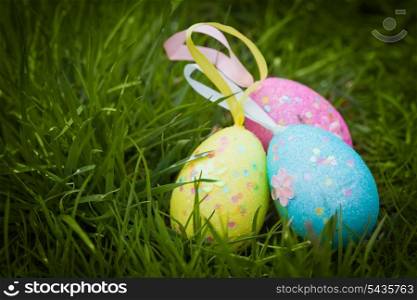 three colorfull easter eggs on green grass
