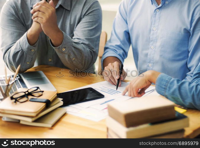 Three confident students reading a book or doing homework together while sitting at home or classroom