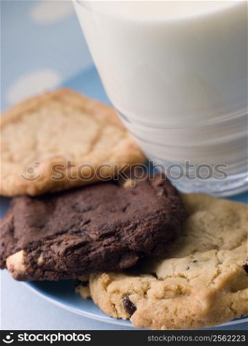 Three Cookies On A Plate With A Glass Of Milk
