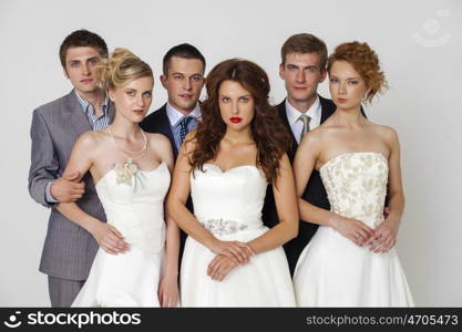 Three couples - wedding studio portrait of the newlyweds, isolated over white background