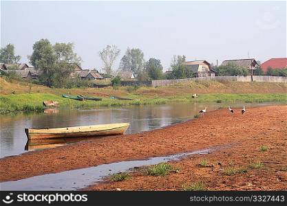 three cranes on coast river near villages
