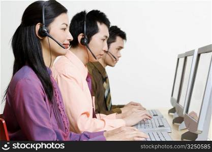 Three customer service representatives working on computers