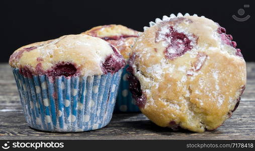 three delicious sweet muffins with cherry berries inside, food ready for eating close up, made in a factory. sweet muffins with cherry berries