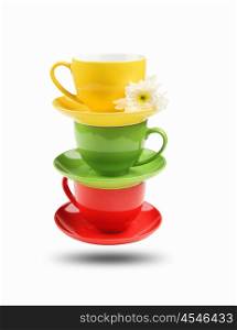 Three different colored cups facing each other on a white background