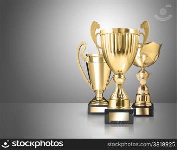 three different kind of golden trophies on gray background
