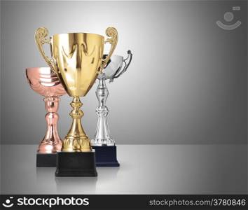three different kind of trophies on gray background