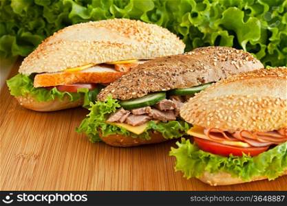 three different sandwich on wood