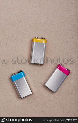 Three discharged batteries on paper background. Collecting used batteries to recycle. Waste disposal and recycling. Copy space for text