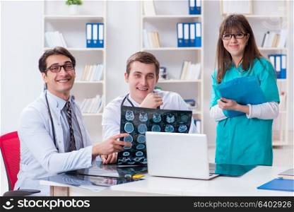 Three doctors discussing scan results of x-ray image