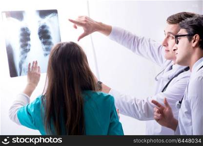 Three doctors discussing scan results of x-ray image