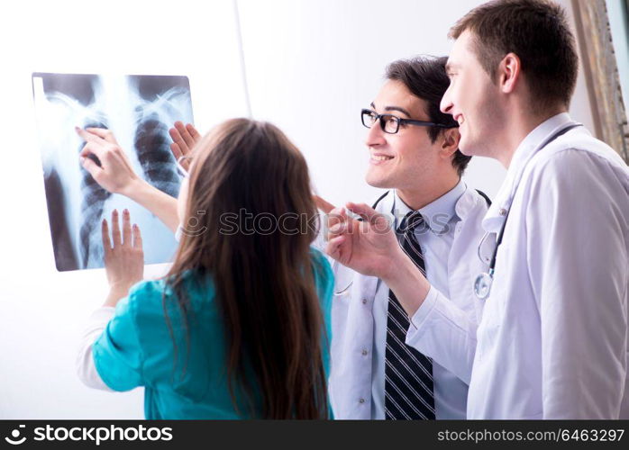 Three doctors discussing scan results of x-ray image