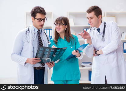 Three doctors discussing scan results of x-ray image